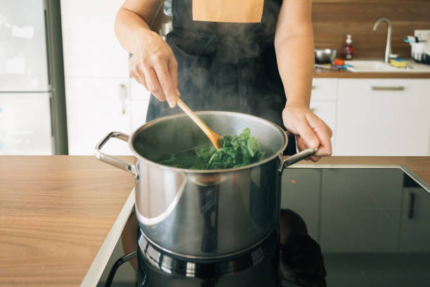 istock A person is cooking spinach in a pot on a stove 2096612177