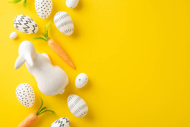 istock Spring holiday theme. Top view of colored eggs, charming rabbit ornament, carrots for the Easter Hare on a lively yellow surface with space for copy or adverts 2096635796
