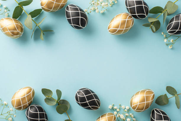 istock Easter piety composition: Top view capturing rich black and gold eggs, eucalyptus greens, gypsophila petals, arranged on a pastel blue backdrop, providing a spot for text or advertising messages 2096635800