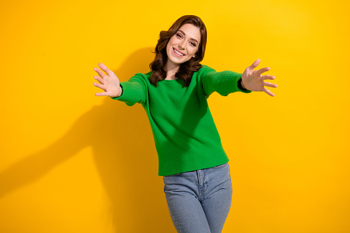 Photo of glad cheerful woman dressed trendy green clothes open hands hug come here isolated on yellow color background.