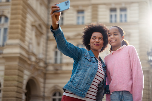 Afro American Young Mother Taking a Selfie with her Daughter Outdoors . Separated Mother Spending Time with her Daughter in the City