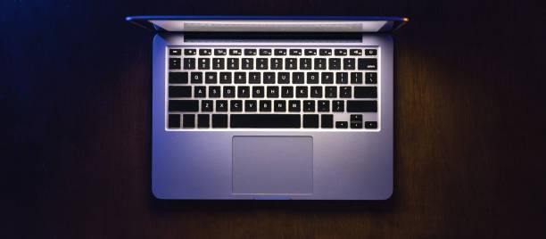 istock Top view of a laptop on a dark table, glowing screen. 2096664391