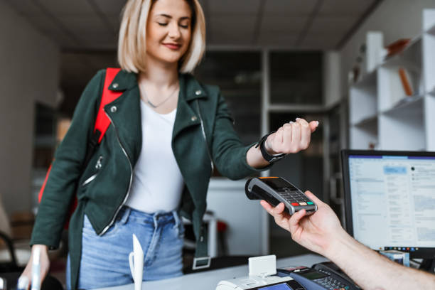 istock Cute Blond Female Using Smartwatch To Pay For Delivery Service In Office 2096677725