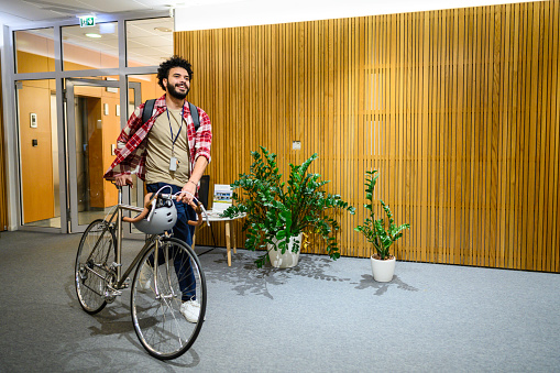 Businessman entering in office with cycle.