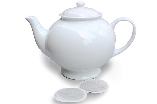 Teapot and tea bags isolated on white background.