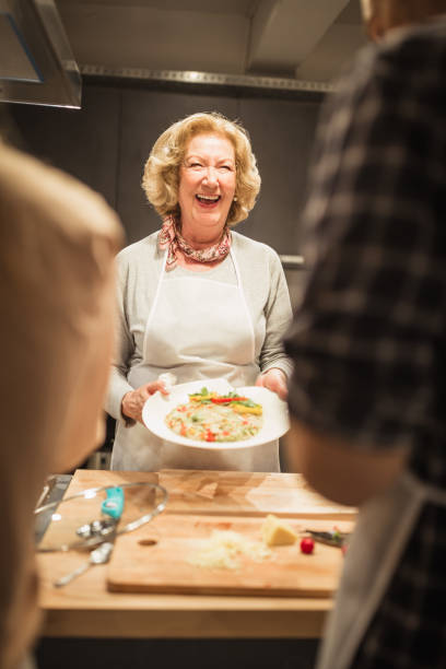 istock Cheerful Caucasian Female Presenting Dish in Cooking Class 2096712001