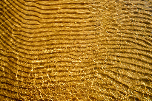 A horizontal pattern of sand under water, created by waves