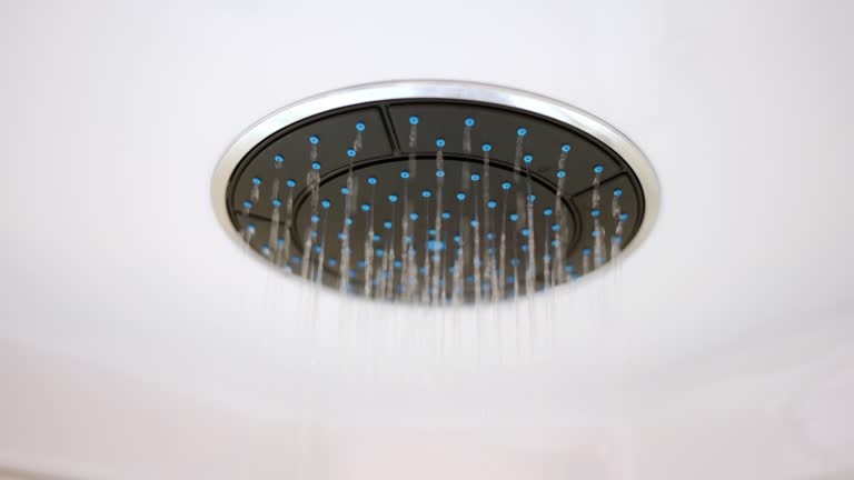 Water flows from a round shower head. The concept of luxury sanitary ware in the bathroom, comfort, modern design.