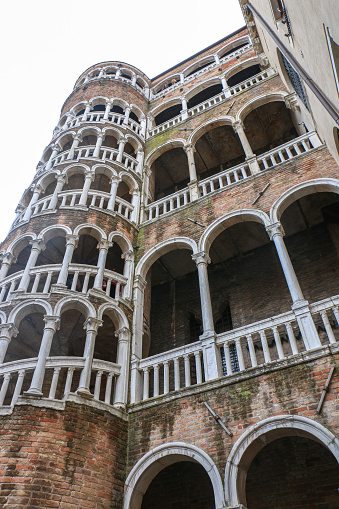 Looking up at the fabulous architecture of the external multi-arch spiral staircase known as Scala Contarini del Bovolo in Venice - Italy