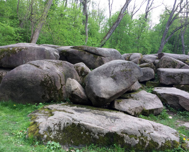 istock Park, spring park, large stones covered with moss, and around trees that are starting to turn green 2096779252