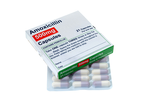 A generic box of Amoxicillin an antibiotic medication with a blister pack of capsules - white background