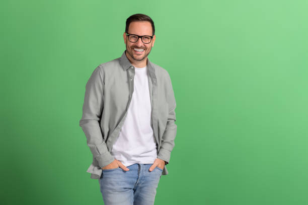 istock Handsome professional with hands in pockets smiling and posing confidently over green background 2096795496