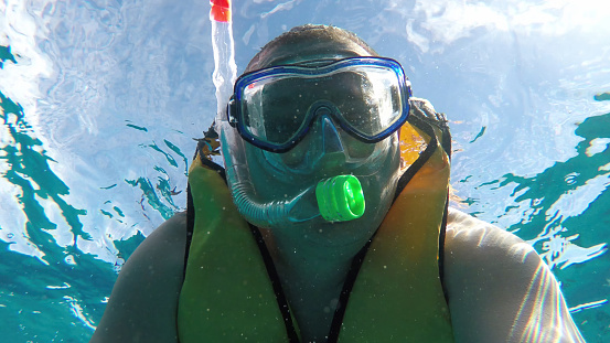 Close-up of a man underwater. A man in a mask and with a snorkel.