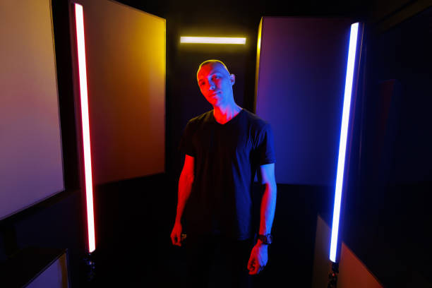 istock Young man poses in a studio in a fashionable neon light. Bright colorful lighting effects. 2096847904