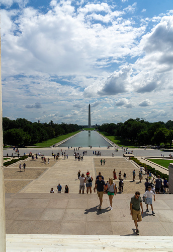 People at the Lincoln Memorial with the Reflecting Pool and Washington Monument in the background in Washington DC.