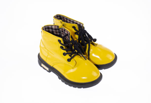 yellow children boots with laces isolated on white background