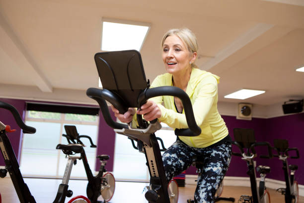 istock Woman using an exercise bike in a gym 2096859762