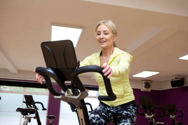 istock Woman using an exercise bike in a gym 2096860301