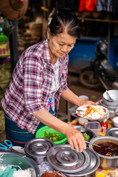 istock Burmese woman serving breakfast, Myanmar 2096861943