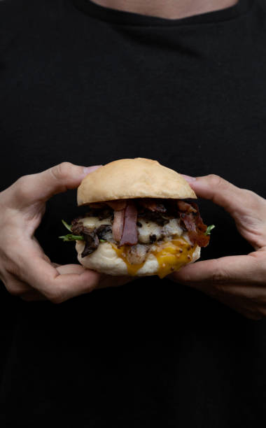 istock A man holding a gourmet burger with bacon 2096871835