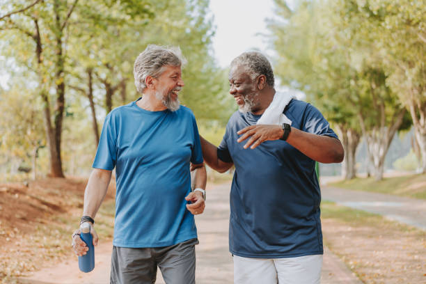 istock Two elderly friends walking together in public park 2096878663