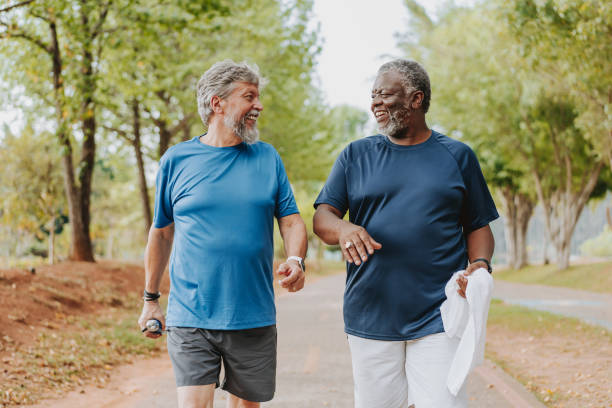 istock Two elderly friends walking together in public park 2096878666