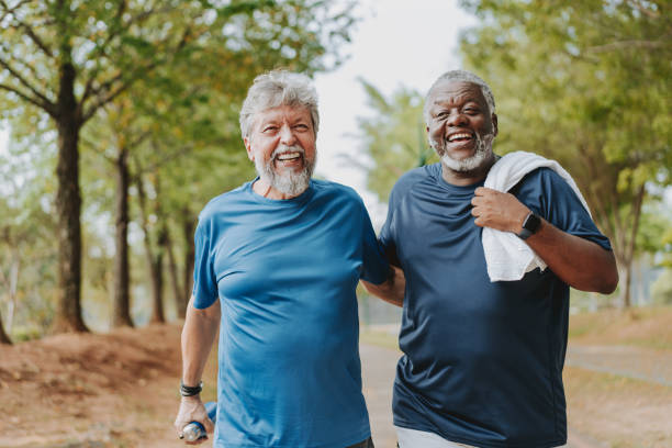 istock Two elderly friends walking together in public park 2096884058
