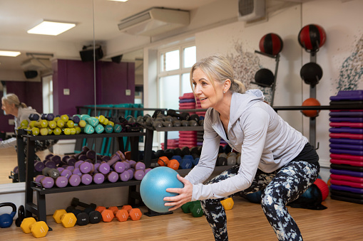 Health and fitness: One mature woman in an exercise studio