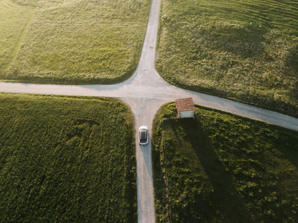 Car in a road intersection A car in a road intersection as seen from directly above crossroad stock pictures, royalty-free photos & images