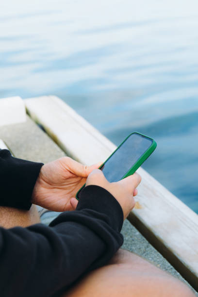 istock Man Surfing Internet by Smartphone by the Sea 2096947742