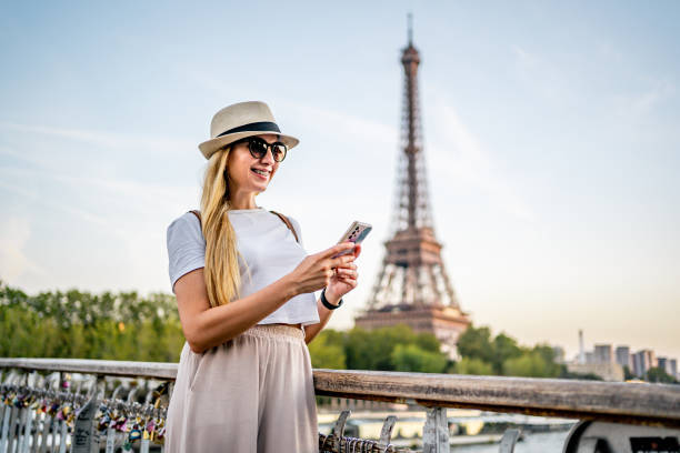 istock Happy woman using phone in front of the Eiffel Tower in Paris 2096972383