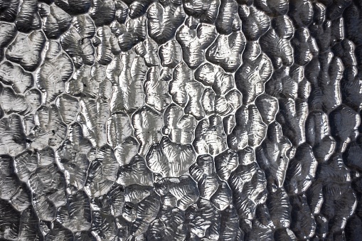 Close-up of wrinkled texture on glass, creating a unique abstract pattern.