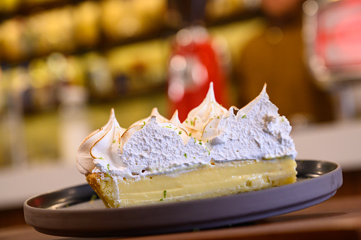 Freshly baked lemon meringue pie with toasted peaks, served on a wooden table
