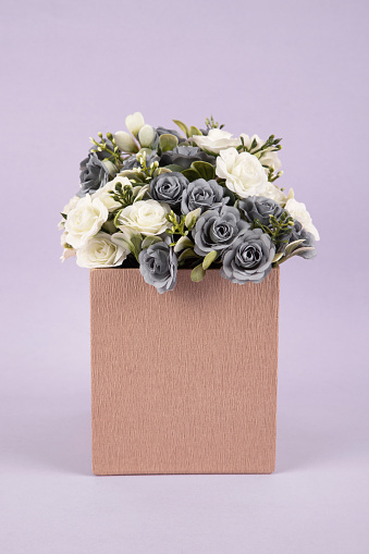 Gift box full of flower on purple background
