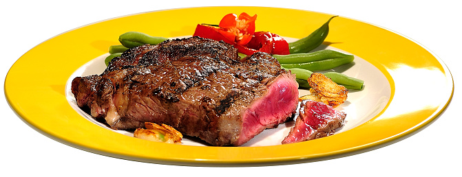 Image of black pepper pork steak and french fries on a plate at a dining table