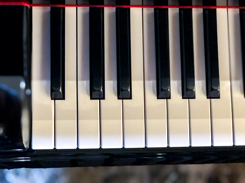 Side view of Piano keys with shallow depth of field. Classic grand piano keyboard background.