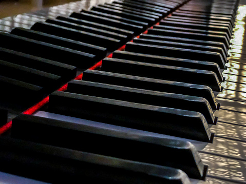 Side view of Piano keys with shallow depth of field. Classic grand piano keyboard background.