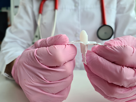 Gloved doctor holds suppositories for anal or vaginal use. Medical candles for treatment of thrush