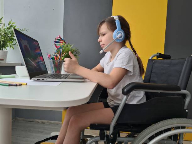 istock Young Girl in Wheelchair Using Laptop 2097029166