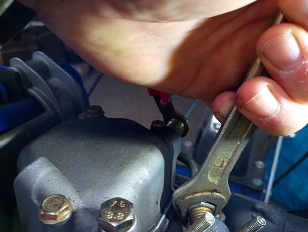 istock Do-it-yourself mini tractor engine repair using a hand tool. In the photo, a man's hand twists the nozzles of the fuel system. 2097050389