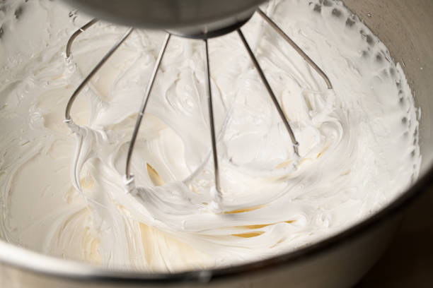 istock Using a mixer, whipping thick white cream from egg whites and sugar 2097060928