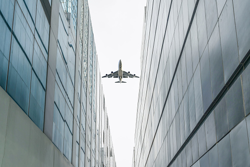 plane fly over modern buildings in downtown.