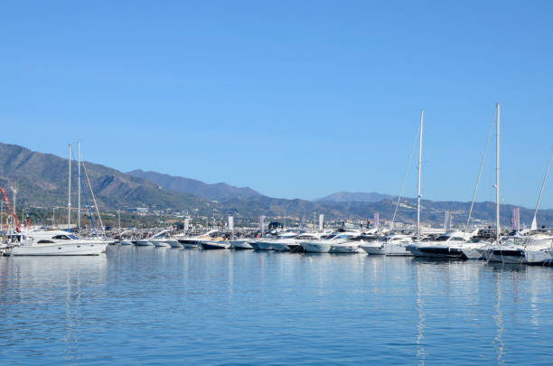 Marbella, Spain - December 10, 2023:  Nautical boats with the mountain at the background of Banus Harbor, in Marbella, Andalusia, Spain.