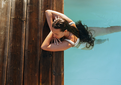 Photo of a young woman relaxing alone in the pool