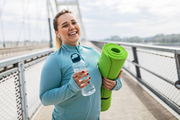 istock Woman Getting Ready to Work Out with Exercise Mat 2097098665