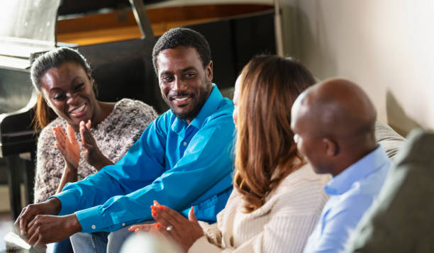 istock African-American friends sitting on sofa, conversing 2097099709