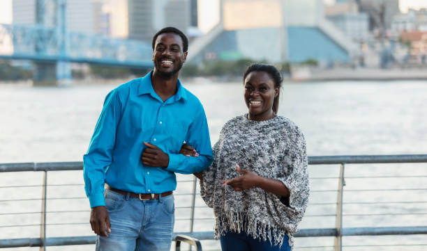 African-American couple smiling on city waterfront