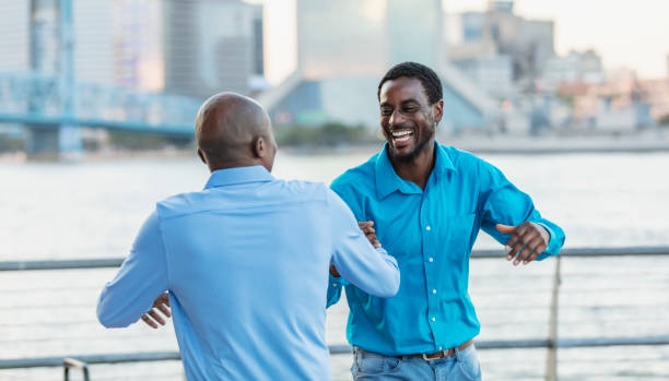 istock Two African-American men greeting on city waterfront 2097100812