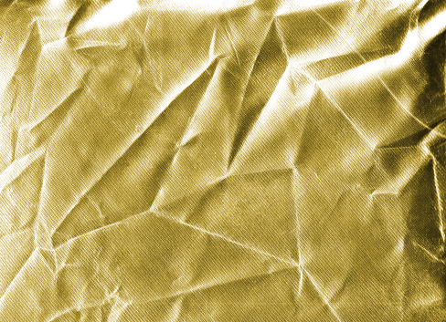 Close-up of wrinkled, shiny, gold, satin-like fabric