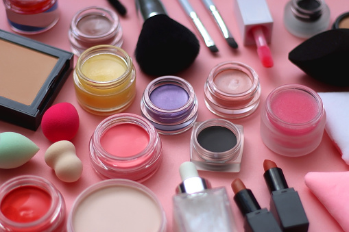 Various colorful beauty products on bright pink background. Selective focus.